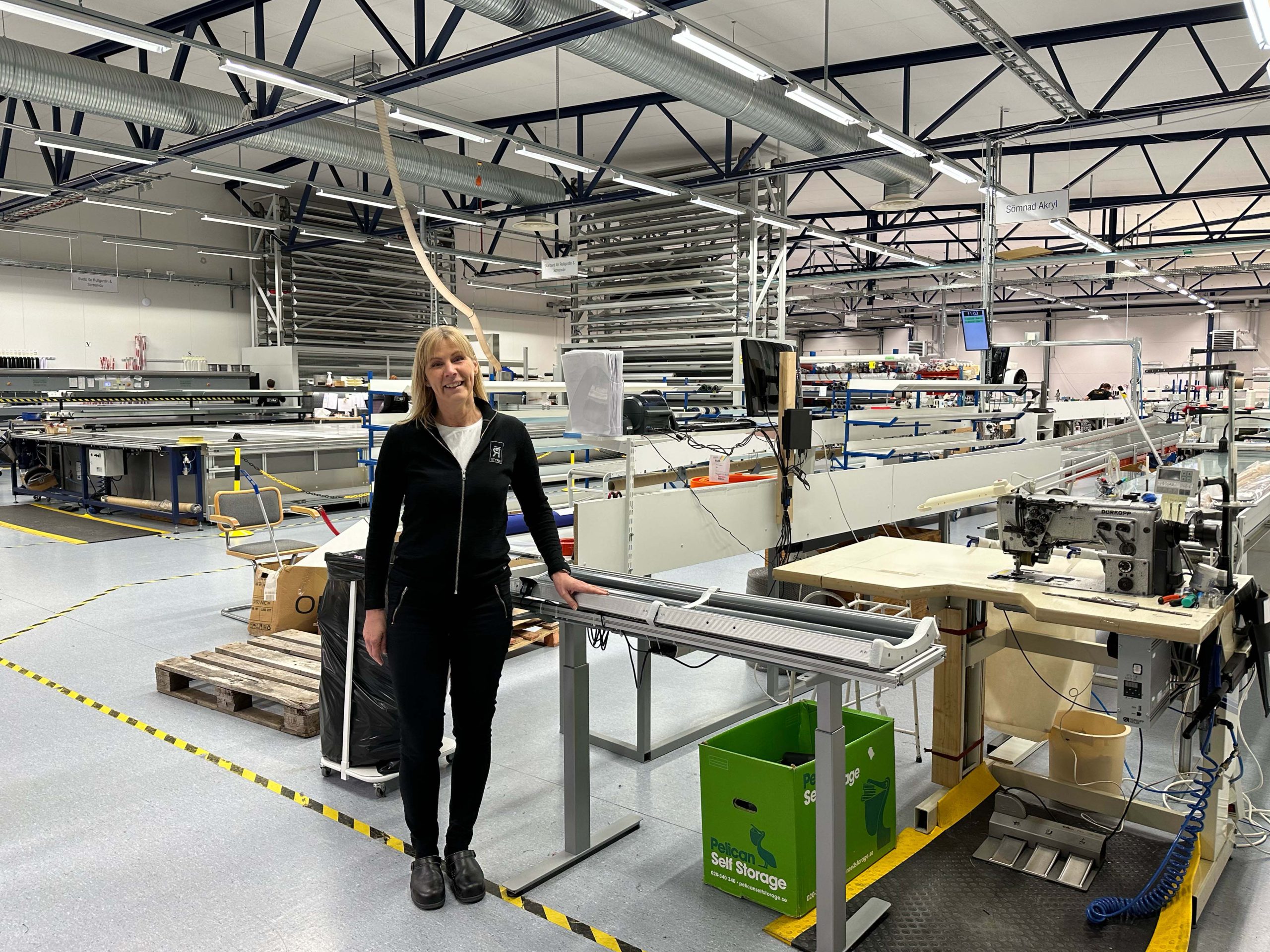 Ingela Lundberg i svarta kläder står i en produktionsanläggning